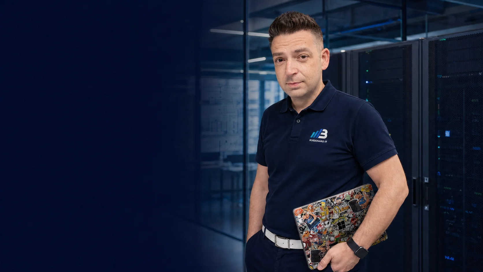 Dino Bordonaro im BORDONARO-IT-Polo mit seinem markanten Notebook im Rechenzentrum